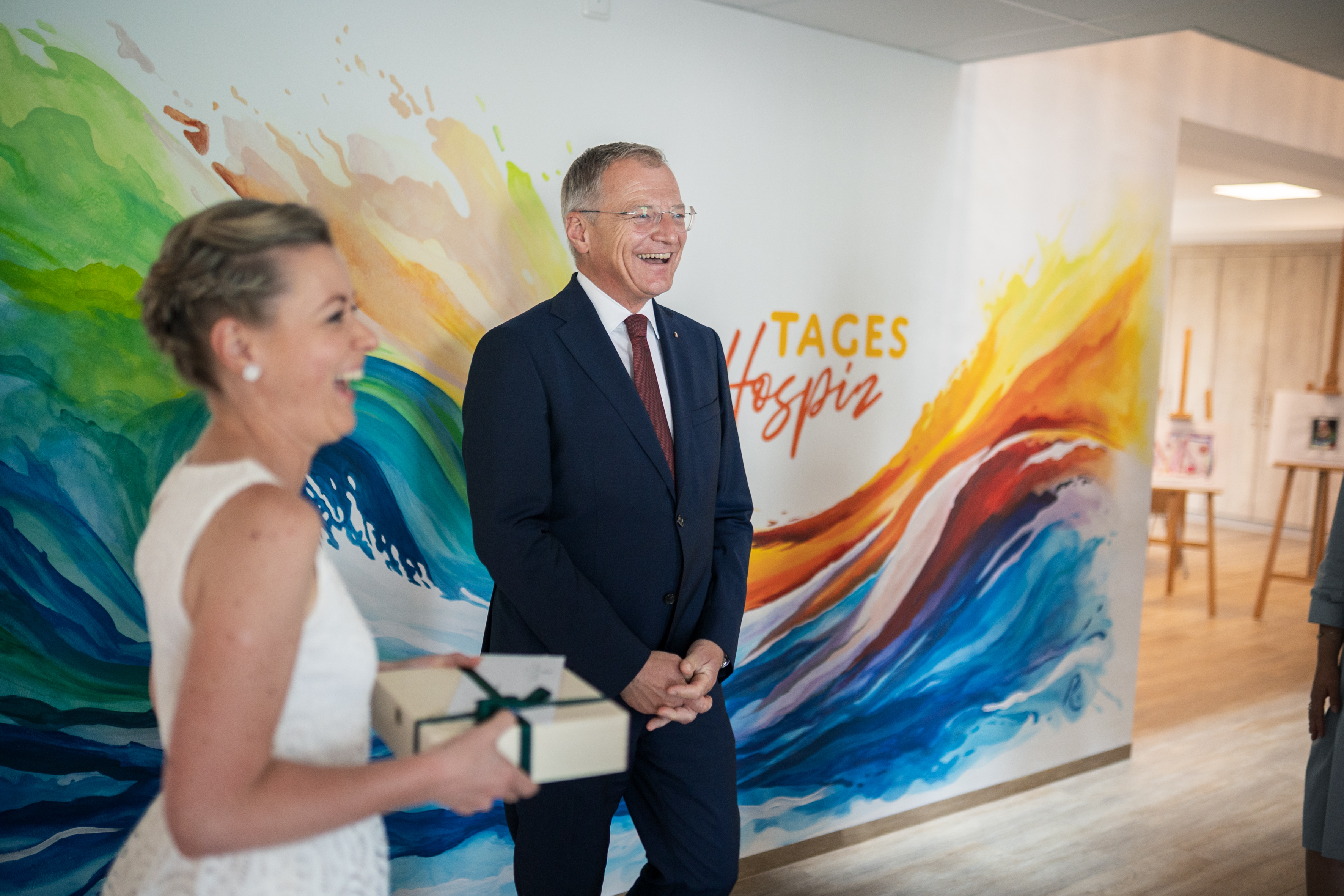 Präsent-Übergabe / Land OOE Das Bild zeigt eine Frau mit einem Präsent in der Hand, daneben steht Landeshauptmann Thomas Stelzer.