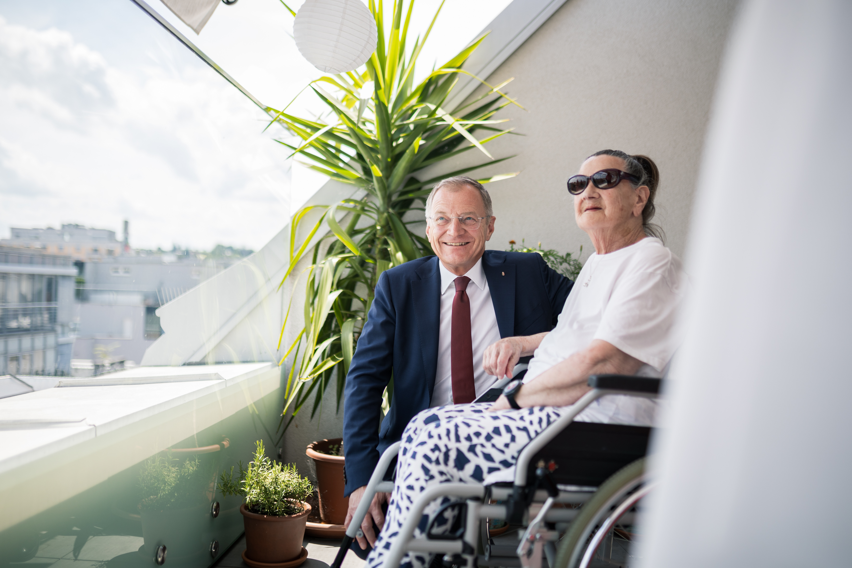 Landeshauptmann und Bewohnerin / Land OOE Das Bild zeigt Landeshauptmann Thomas Stelzer mit einer Bewohnerin im Rollstuhl.