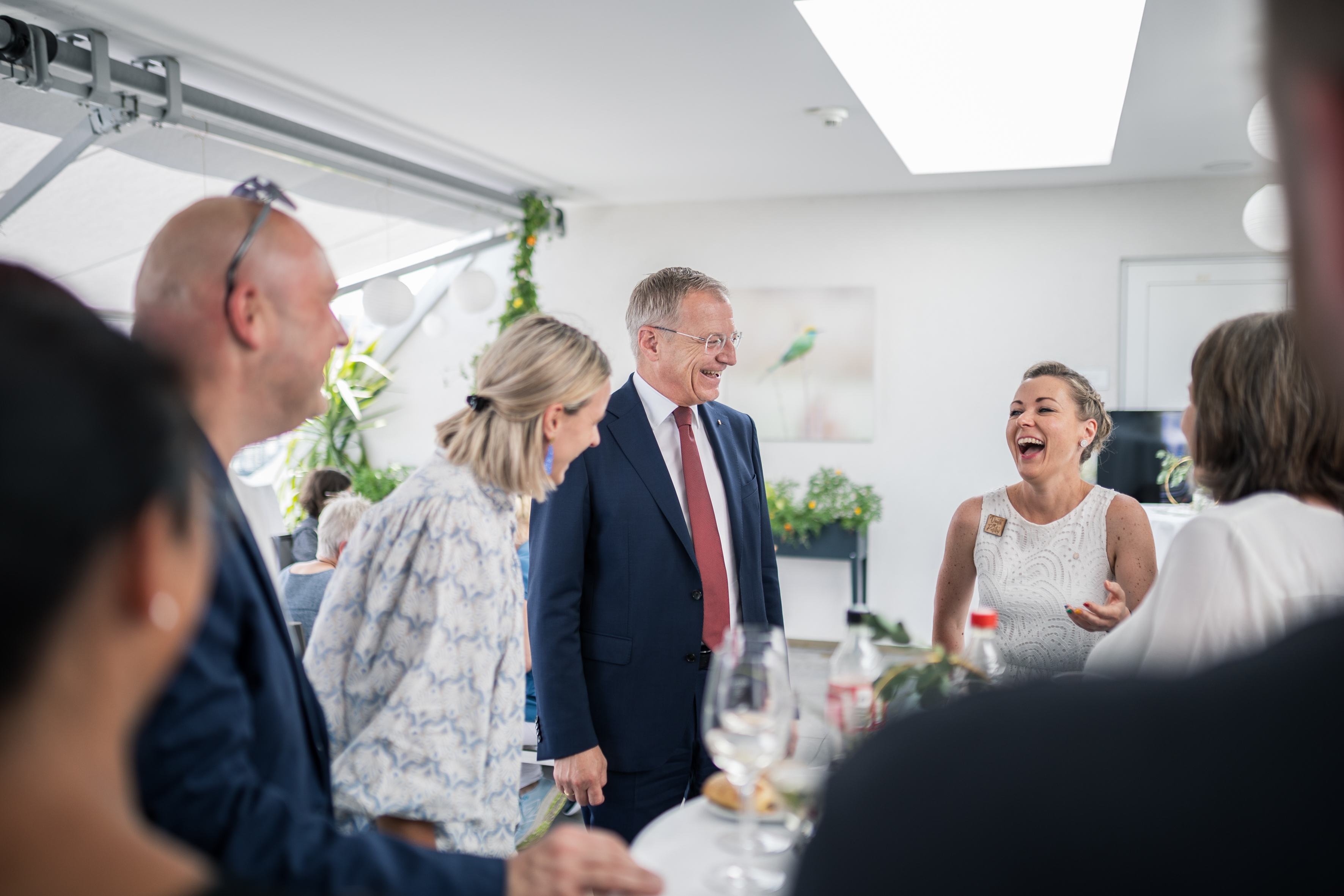 Landeshauptmann im Gespräch / Land OOE Der Landeshauptmann ist im Gespräch mit Mitarbeiter*innen des Hospiz. Dabei wirken alle Beteiligten sehr fröhlich.
